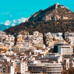 city buildings near mountain under blue sky during daytime